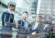 Young businessmen talk against the backdrop of modern office buildings