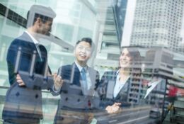 Young businessmen talk against the backdrop of modern office buildings